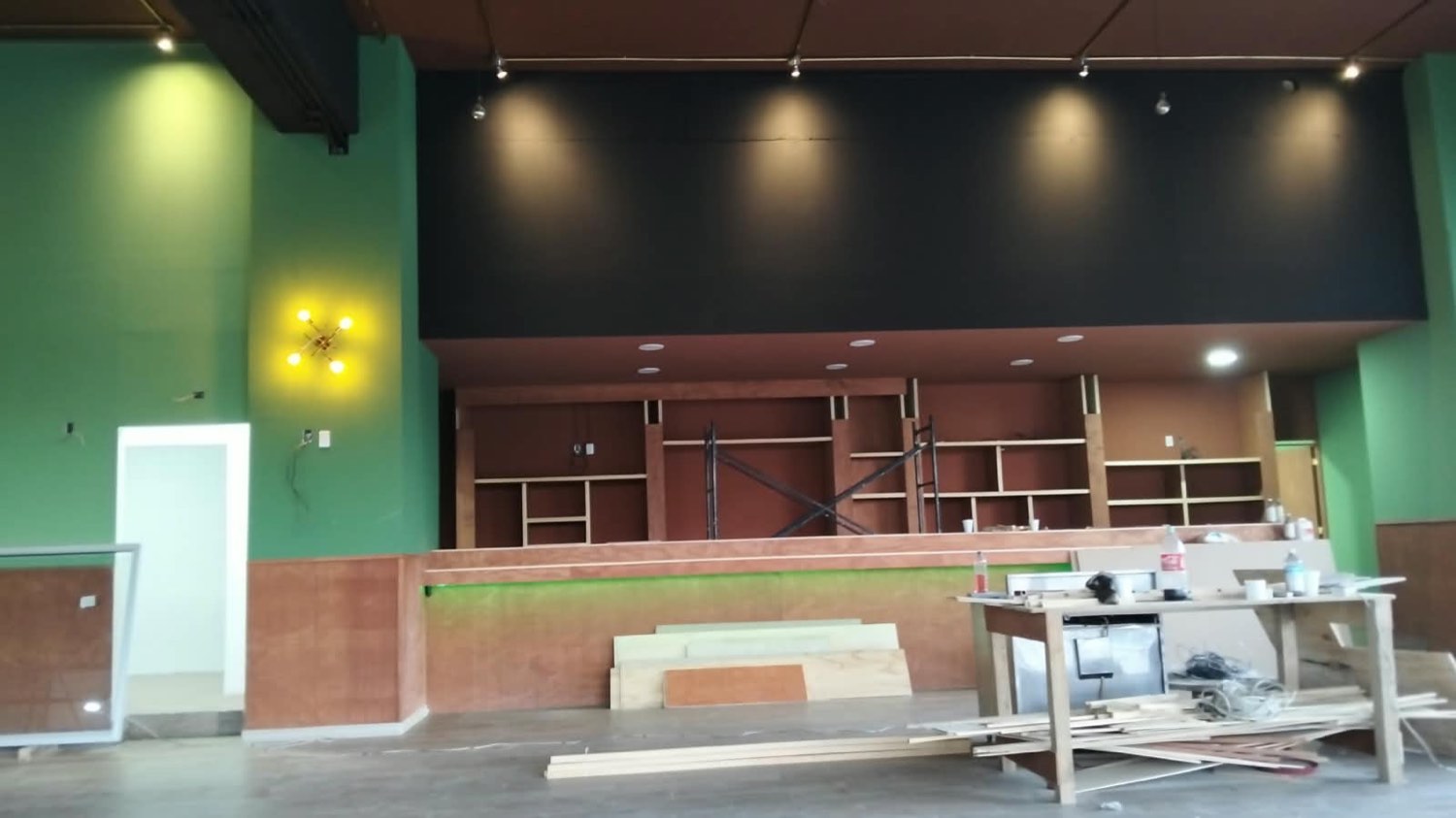 Local comercial con muros de tablarroca, entrepaños de madera y luz dirigida