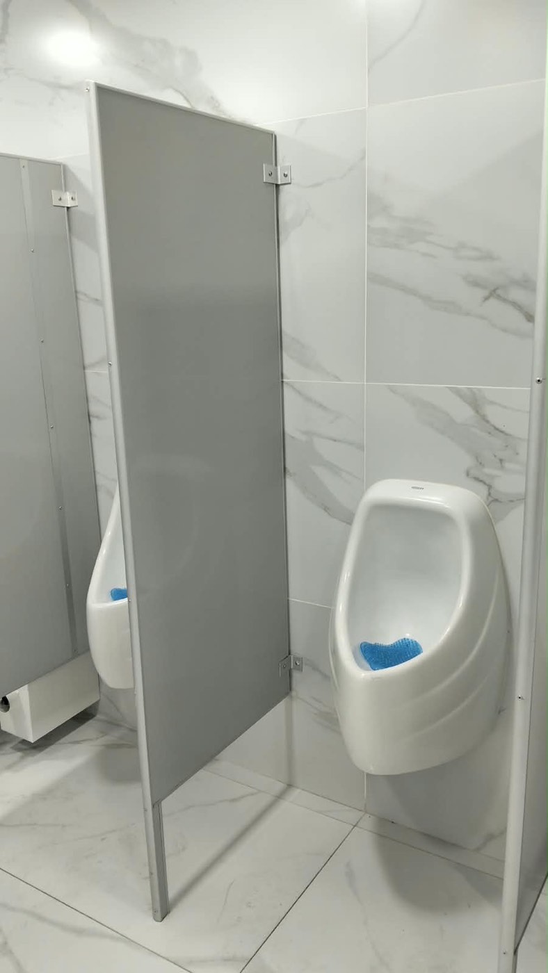 Sanitarios comerciales terminados con muros de porcelánico claro